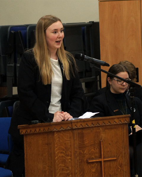 Grace Hands, Year 13 and Sixth Form worship co-ordinator, introducing the first worship song.